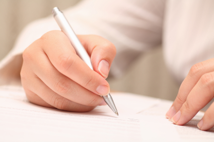 A doctor's hand writing a medical manuscript